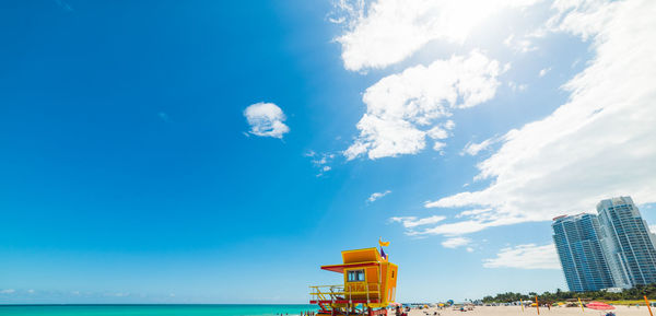 Building by sea against blue sky