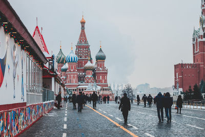 People on street against st basil cathedral during winter