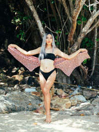 Portrait of young trans woman standing on rock