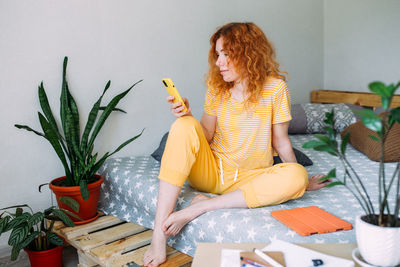 Portrait of woman sitting on table at home