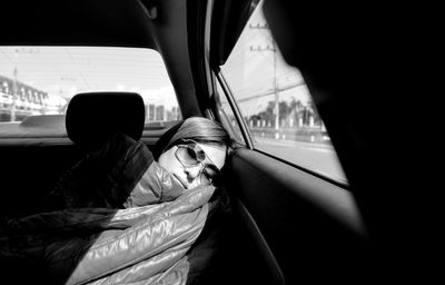 Woman wearing sunglasses sleeping in car