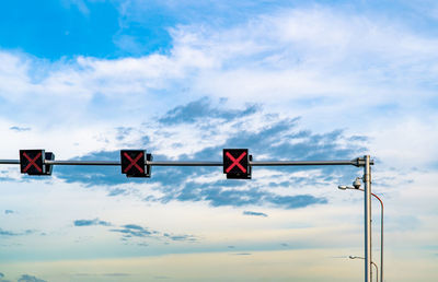 Low angle view of road signal against sky