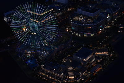 High angle view of illuminated ferris wheel in city at night