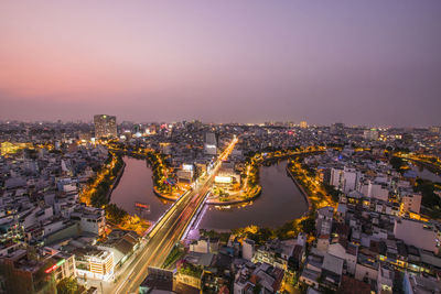 High angle view of illuminated city against sky at dusk