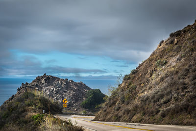 Road amidst rocks against sky