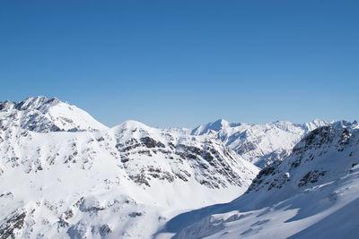 Scenic view of snowcapped mountains against clear blue sky