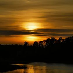 Scenic view of lake against orange sky