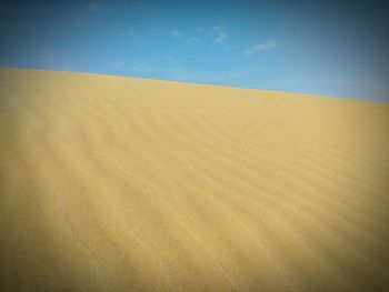 Sand dunes in desert against sky