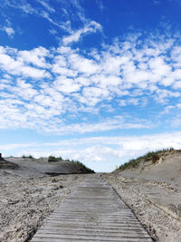 Dirt road along landscape and against sky