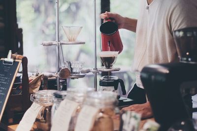 Close-up of man pouring coffee in cafe