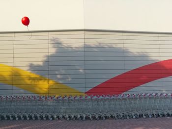 Shopping carts arranged against wall in sunny day