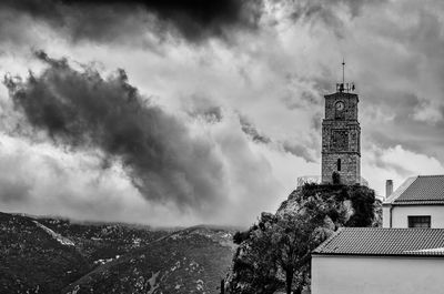 Low angle view of tower against cloudy sky