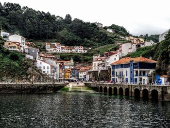 River amidst buildings in town against sky