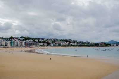 Scenic view of beach against cloudy sky