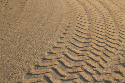 High angle view of tire tracks pattern on beach sand