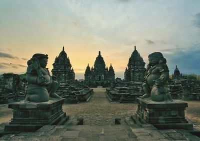 Temple against buildings at sunset