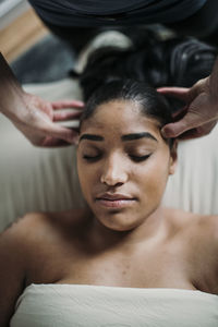 African american woman receives scalp massage from therapist