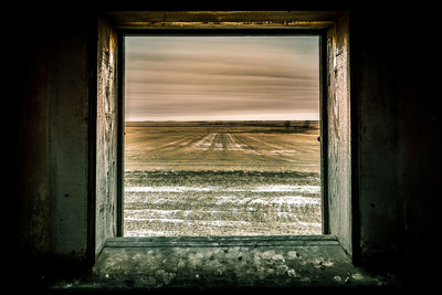 Scenic view of field seen through window