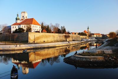 River by old building against clear sky