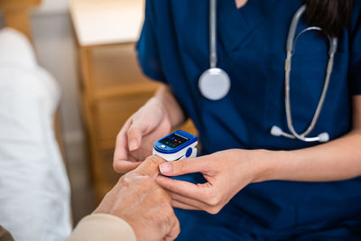 Midsection of doctor examining patient