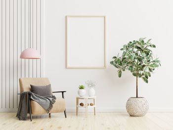 Poster mockup with vertical frames on empty white wall in living room interior.3d rendering