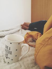 Low section of woman holding coffee cup