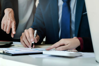 Midsection of couple holding hands on table