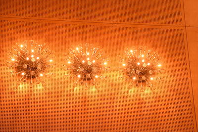 Firework display over illuminated christmas lights at night