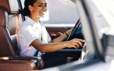 Side view of woman sitting in car