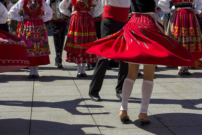 Low section of people walking on street in city