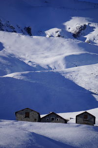 Scenic view of snow covered landscape and houses against sky