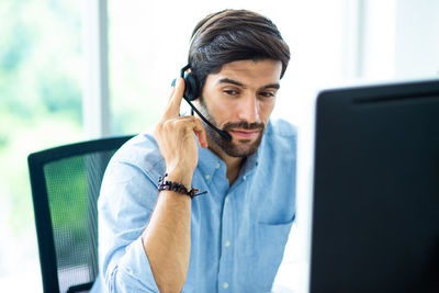 Businessman talking through headset in office