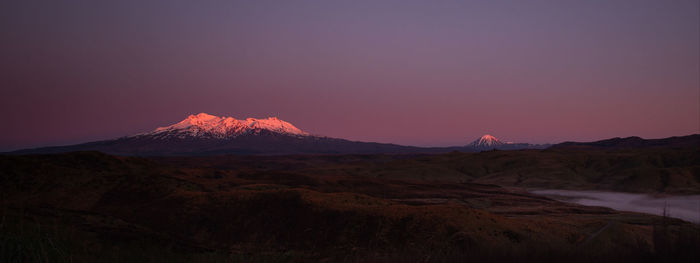 Scenic view of mountains against clear sky during sunset