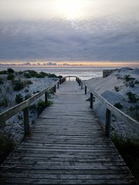 View of pier over sea against sky during sunset