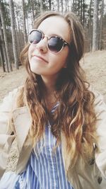 Portrait of young woman wearing sunglasses standing outdoors