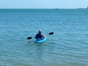 Rear view of man in sea against sky