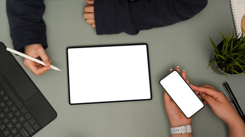 Cropped hands of woman using laptop on table