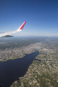 Aerial view of airplane wing over cityscape