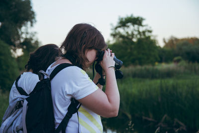 Woman photographing with camera on field