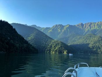 Scenic view of lake and mountains against blue sky