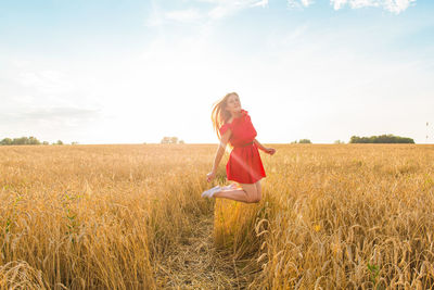 Full length of woman standing on field against sky