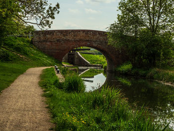 Arch bridge over river against sky