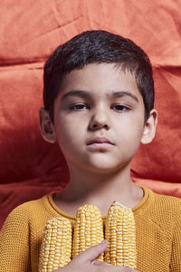 Close-up portrait of boy standing against wall