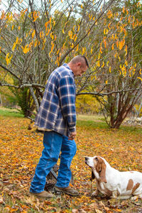 Side view of man standing by tree