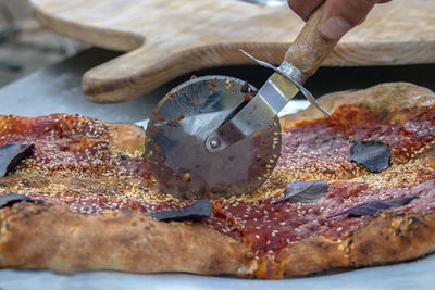 Pizza with tomato sauce, sesame and basil.