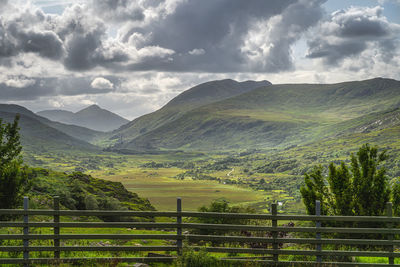 View from behind wooden fence on beautiful molls gap with owenreagh river, ring of kerry, ireland