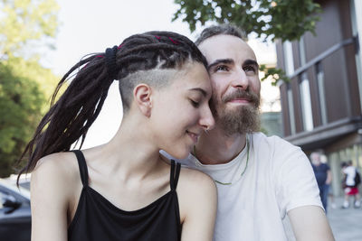 Smiling man with loving non-binary hipster
