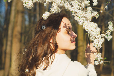 Portrait of young beautiful woman among flowering trees. fashion and beauty. spring concept