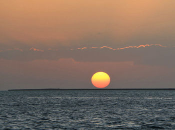 Scenic view of sea against orange sky