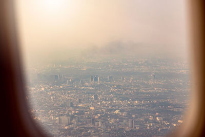 Aerial view of city against sky seen through window